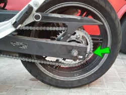 La cadena se afloja frecuentemente, ya que su tensor (indicado por la flecha) es el punto mas débil de la moto.